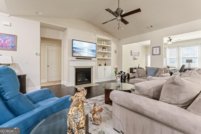 2844 Bluestone Dr SW, South Fulton, GA 30331 - living room featuring ceiling fan, a fireplace with flush hearth, built in features, vaulted ceiling, and wood finished floors
