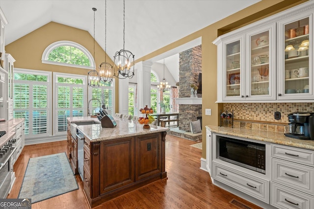 9125 Patrick Pl, Winston, GA 30187 - kitchen with appliances with stainless steel finishes, a chandelier, light stone counters, wood finished floors, and high vaulted ceiling