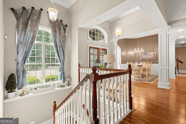 9125 Patrick Pl, Winston, GA 30187 - staircase featuring decorative columns, a chandelier, wood finished floors, a high ceiling, and a decorative wall