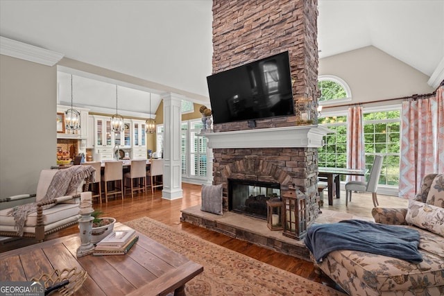9125 Patrick Pl, Winston, GA 30187 - living area featuring a chandelier, ornate columns, high vaulted ceiling, light wood finished floors, and a stone fireplace
