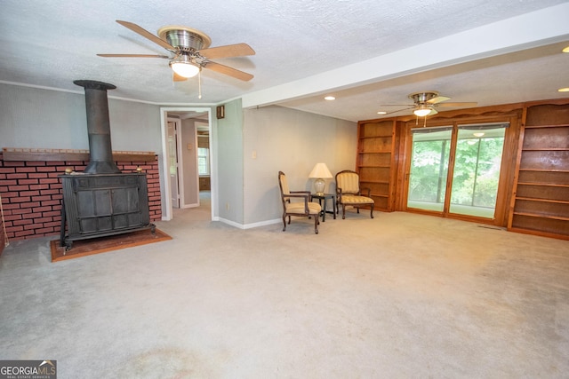 195 Hudgen Rd, Newnan, GA 30265 - sitting room featuring ceiling fan, a wood stove, carpet, and a textured ceiling