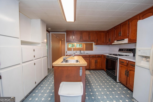 195 Hudgen Rd, Newnan, GA 30265 - kitchen featuring white refrigerator with ice dispenser, gas stove, under cabinet range hood, light countertops, and an island with sink