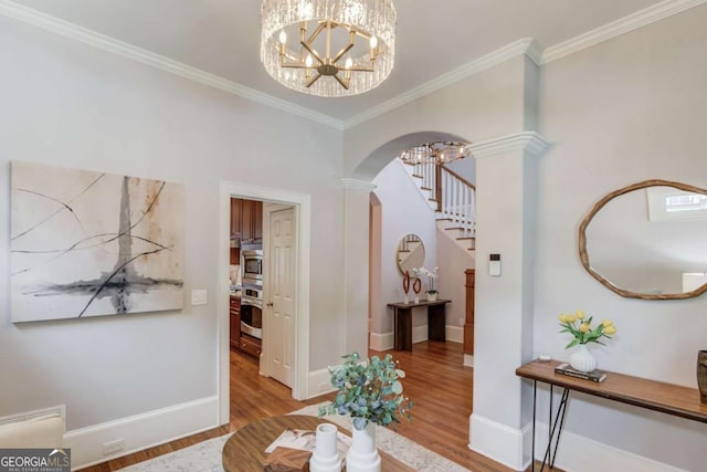 260 W Peachtree St, Norcross, GA 30071 - entrance foyer with arched walkways, wood finished floors, a chandelier, stairway, and crown molding