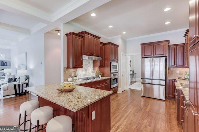 260 W Peachtree St, Norcross, GA 30071 - kitchen with appliances with stainless steel finishes, under cabinet range hood, a peninsula, light wood finished floors, and a breakfast bar area