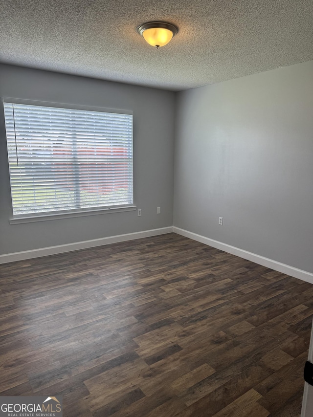 1013 E Cumberland Ct, Bainbridge, GA 39817 - spare room with dark wood-style flooring and a textured ceiling