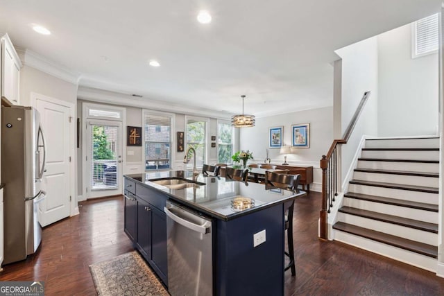 2520 Carmel Way, Alpharetta, GA 30009 - kitchen with appliances with stainless steel finishes, a breakfast bar, ornamental molding, dark wood-type flooring, and a kitchen island with sink