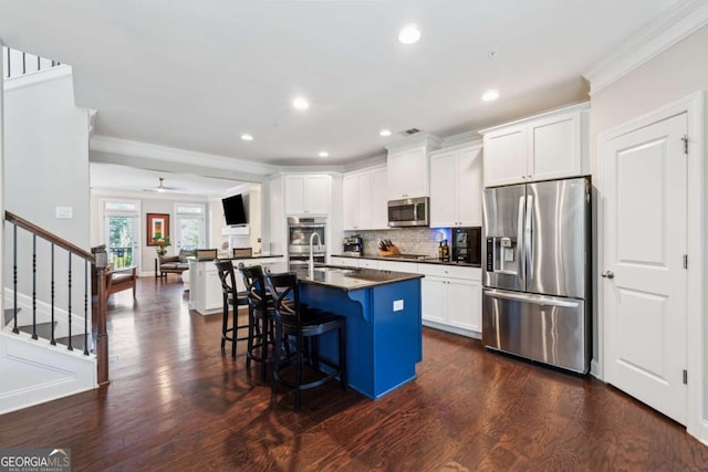 2520 Carmel Way, Alpharetta, GA 30009 - kitchen with stainless steel appliances, dark countertops, crown molding, a kitchen breakfast bar, and dark wood-style floors