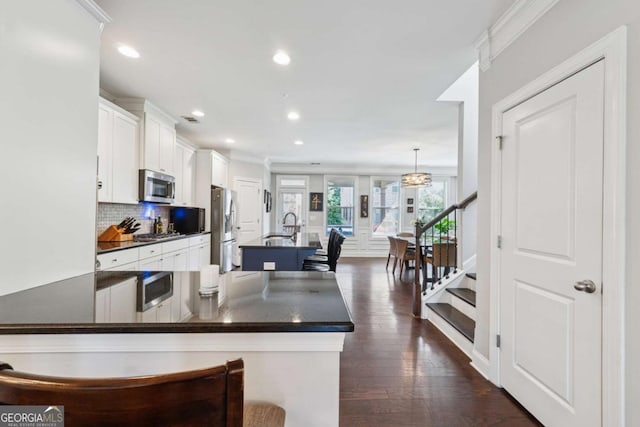 2520 Carmel Way, Alpharetta, GA 30009 - kitchen with stainless steel appliances, dark countertops, white cabinetry, dark wood-style floors, and decorative backsplash