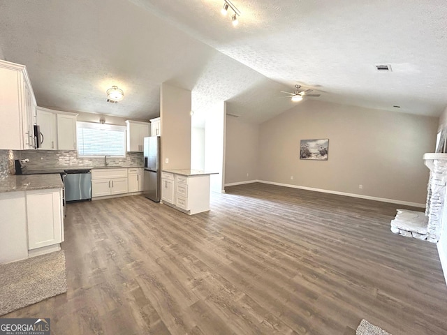 35 Belmont Way, Covington, GA 30016 - unfurnished living room featuring a textured ceiling, a ceiling fan, lofted ceiling, and wood finished floors