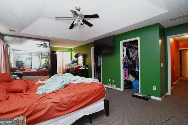 860 Sweet Mill Ln, Lawrenceville, GA 30045 - carpeted bedroom featuring a tray ceiling, ceiling fan, and a walk in closet