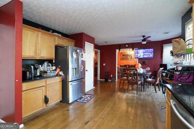 860 Sweet Mill Ln, Lawrenceville, GA 30045 - kitchen featuring appliances with stainless steel finishes, ceiling fan, light wood finished floors, dark countertops, and a textured ceiling