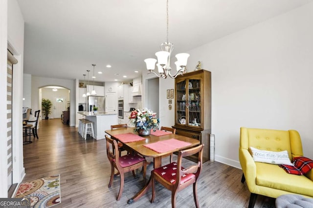 5744 Cypress Bluff Ln, Hoschton, GA 30548 - dining room featuring arched walkways, wood finished floors, a chandelier, and recessed lighting