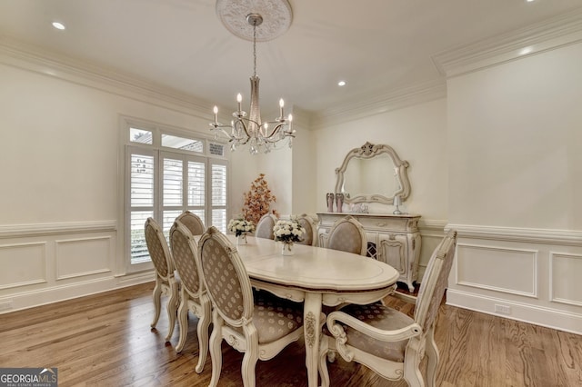 8230 Royal Melbourne Way, Duluth, GA 30097 - dining room featuring a chandelier, wood finished floors, a decorative wall, wainscoting, and recessed lighting