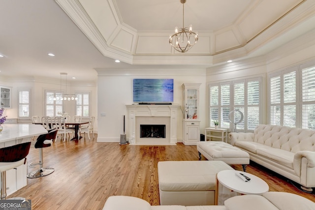 8230 Royal Melbourne Way, Duluth, GA 30097 - living room with a chandelier, ornamental molding, light wood-style flooring, a fireplace with flush hearth, and recessed lighting