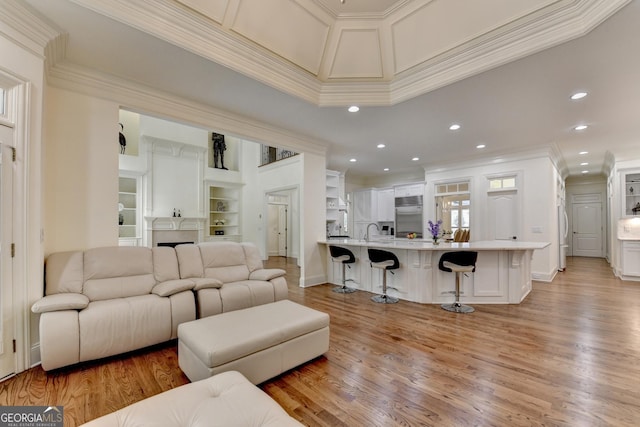 8230 Royal Melbourne Way, Duluth, GA 30097 - living area featuring crown molding, light wood-style floors, recessed lighting, built in features, and a fireplace