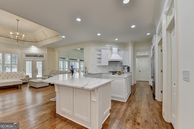 8230 Royal Melbourne Way, Duluth, GA 30097 - kitchen featuring custom exhaust hood, ornamental molding, open shelves, white cabinetry, and open floor plan