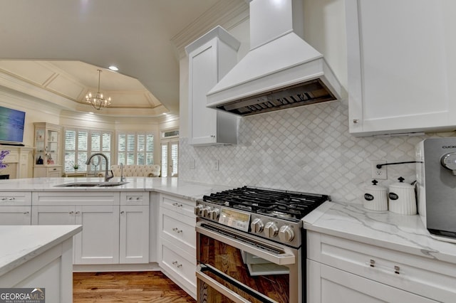 8230 Royal Melbourne Way, Duluth, GA 30097 - kitchen featuring premium range hood, stainless steel gas stove, a chandelier, ornamental molding, and decorative backsplash