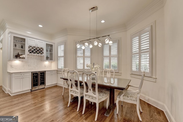 8230 Royal Melbourne Way, Duluth, GA 30097 - dining area featuring wine cooler, a dry bar, light wood-style flooring, ornamental molding, and recessed lighting