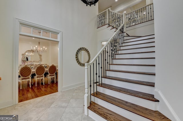 8230 Royal Melbourne Way, Duluth, GA 30097 - staircase featuring a chandelier, a high ceiling, and tile patterned flooring