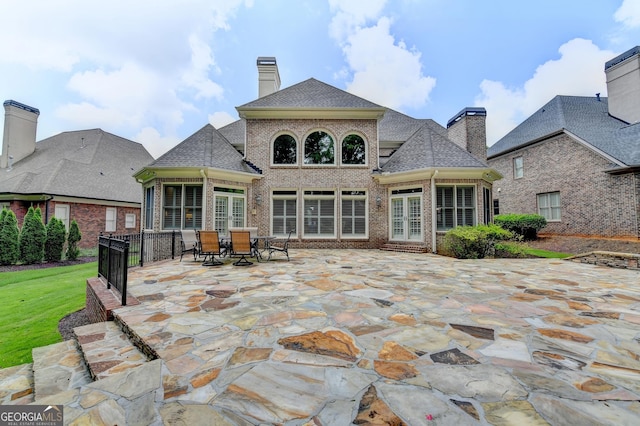 8230 Royal Melbourne Way, Duluth, GA 30097 - back of house featuring brick siding, a patio, a chimney, french doors, and a shingled roof
