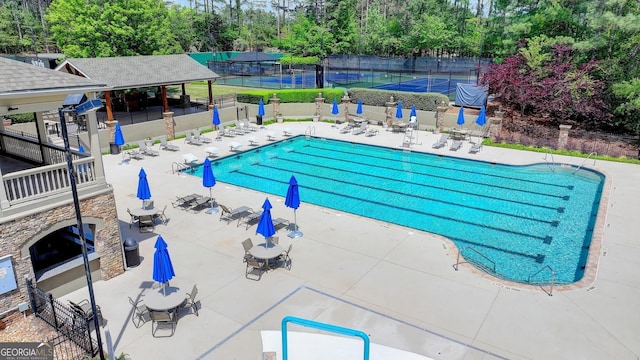 8230 Royal Melbourne Way, Duluth, GA 30097 - community pool with a tennis court, a patio area, and view of scattered trees