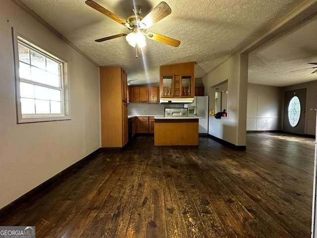 3171 Wagnon Mill Rd, Bishop, GA 30621 - kitchen with open floor plan, brown cabinets, freestanding refrigerator, dark wood finished floors, and a textured ceiling