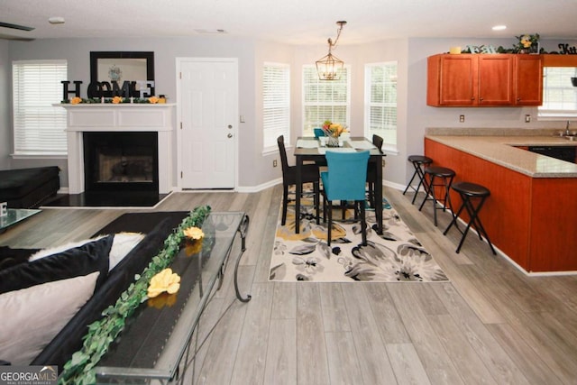 1964 Cutters Mill Way, Lithonia, GA 30058 - dining room featuring light wood-style floors, a glass covered fireplace, and a chandelier