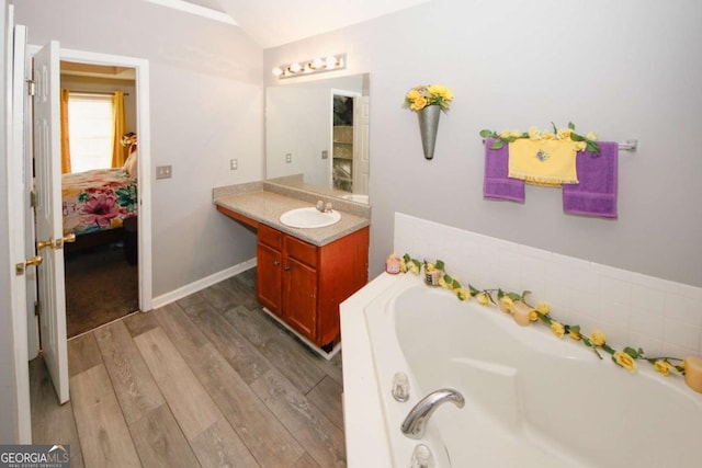 1964 Cutters Mill Way, Lithonia, GA 30058 - full bathroom with a bath, vanity, ensuite bathroom, lofted ceiling, and wood finished floors