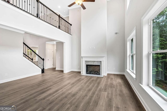 7449 Waterview Cv, Douglasville, GA 30135 - unfurnished living room featuring ceiling fan, dark wood-style floors, healthy amount of natural light, a high ceiling, and stairs
