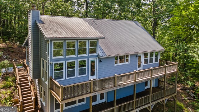832 Round Top Dr, Clayton, GA 30525 - back of house with a chimney, stairway, a wooden deck, a metal roof, and view of wooded area