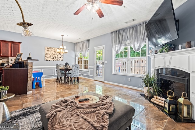3832 Augustine Pl, Rex, GA 30273 - living room featuring marble tiled floors, a decorative wall, a chandelier, a fireplace with raised hearth, and ceiling fan