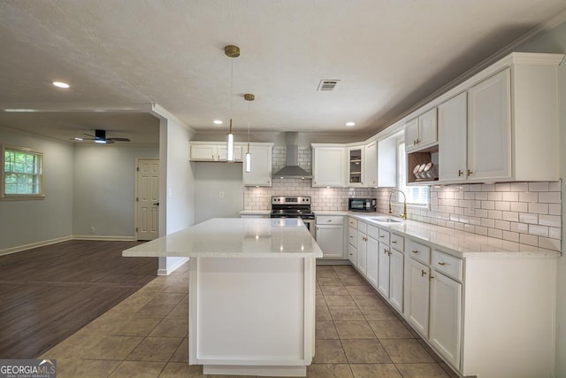 7144 Carolyn Cir, Lithia Springs, GA 30122 - kitchen featuring wall chimney range hood, stainless steel range with electric stovetop, tasteful backsplash, healthy amount of natural light, and recessed lighting