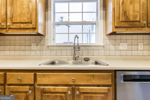 132 Hidden Creek Cir, Lizella, GA 31052 - kitchen featuring dishwasher, brown cabinets, light countertops, and tasteful backsplash