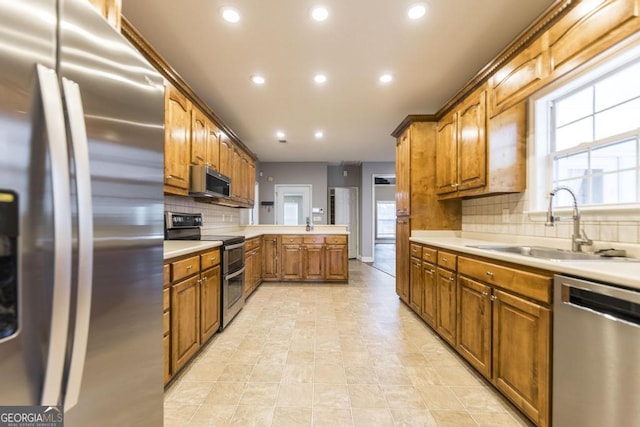 132 Hidden Creek Cir, Lizella, GA 31052 - kitchen with appliances with stainless steel finishes, recessed lighting, decorative backsplash, brown cabinets, and light countertops