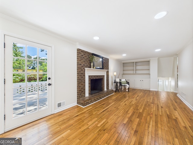 4630 Glenwood Dr, Macon, GA 31210 - unfurnished living room featuring light wood-style flooring, a fireplace, ornamental molding, built in features, and recessed lighting