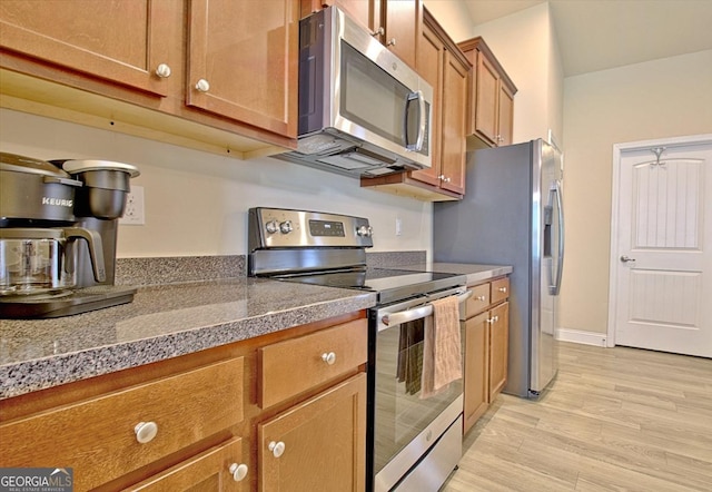 862 Crescent Ln, Griffin, GA 30224 - kitchen with appliances with stainless steel finishes, brown cabinets, and light wood-type flooring