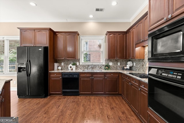 1065 Beacon Hill Xing, Alpharetta, GA 30005 - kitchen featuring black appliances, healthy amount of natural light, light stone countertops, dark wood-style floors, and crown molding