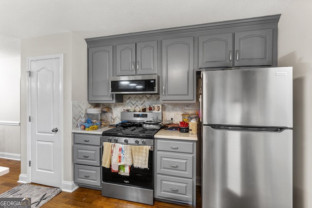 408 Dixieland Dr, Byron, GA 31008 - kitchen with appliances with stainless steel finishes, gray cabinets, backsplash, dark wood-type flooring, and light countertops