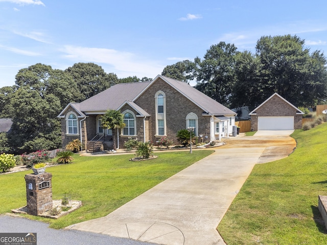 408 Dixieland Dr, Byron, GA 31008 - view of front facade featuring concrete driveway, a detached garage, brick siding, a front lawn, and an outdoor structure