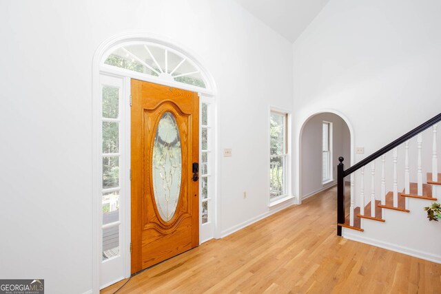 5491 Hiram Rd, Powder Springs, GA 30127 - foyer featuring arched walkways, wood finished floors, stairs, and high vaulted ceiling