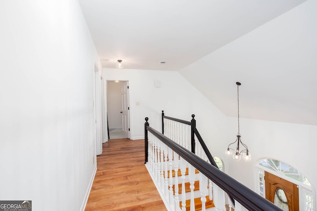 5491 Hiram Rd, Powder Springs, GA 30127 - hallway with an upstairs landing, a chandelier, light wood-style floors, and vaulted ceiling