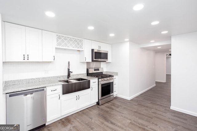 5491 Hiram Rd, Powder Springs, GA 30127 - kitchen with stainless steel appliances, wood finished floors, light stone counters, recessed lighting, and white cabinets