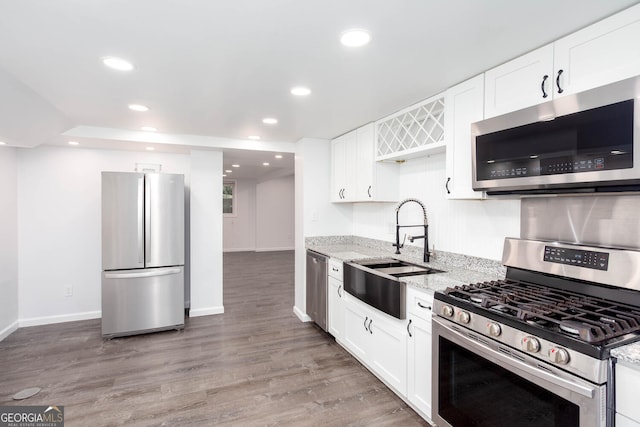 5491 Hiram Rd, Powder Springs, GA 30127 - kitchen with appliances with stainless steel finishes, light stone countertops, recessed lighting, white cabinetry, and light wood-style flooring