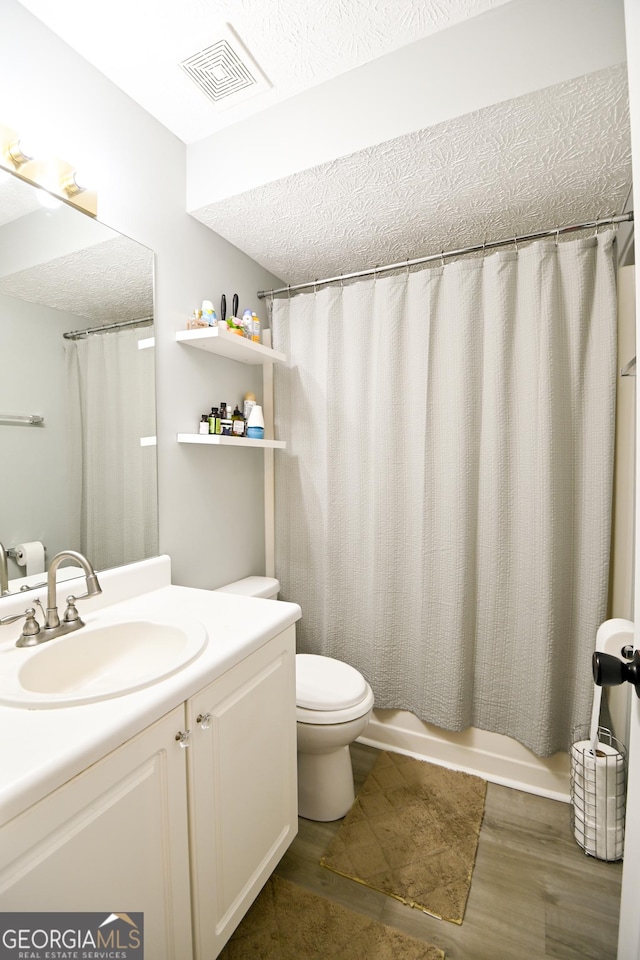 432 Nicole Ct, Winder, GA 30680 - bathroom with vanity, wood finished floors, shower / bath combo with shower curtain, and a textured ceiling