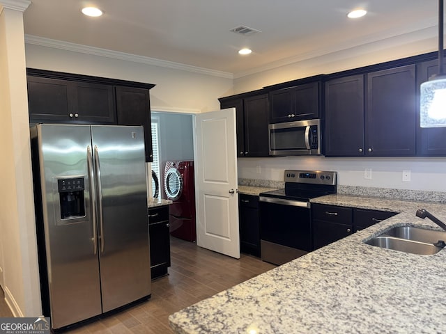 3891 Valley View Ct, Gainesville, GA 30501 - kitchen with appliances with stainless steel finishes, washing machine and dryer, light stone counters, wood finished floors, and crown molding