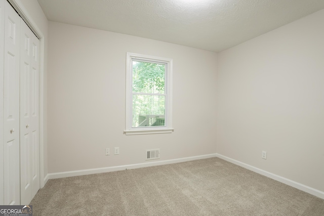 356 Waterway Trl, Powder Springs, GA 30127 - unfurnished bedroom featuring carpet, a closet, and a textured ceiling