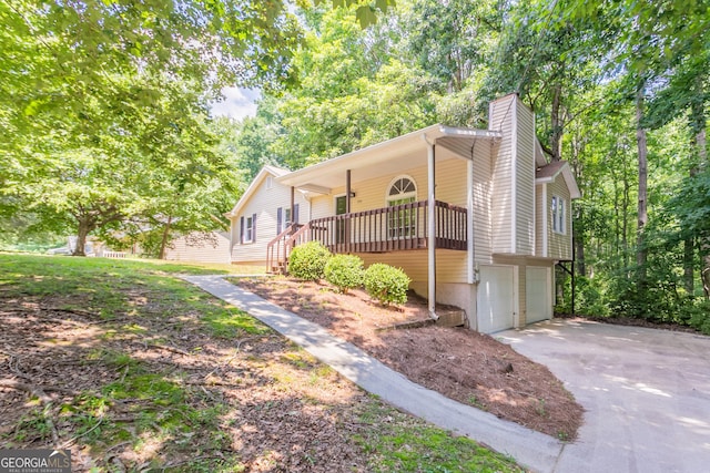 356 Waterway Trl, Powder Springs, GA 30127 - view of front of property featuring a chimney, a garage, driveway, and covered porch