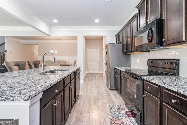 154 Laurel Cove Dr, Hoschton, GA 30548 - kitchen with black appliances, light stone countertops, light wood-type flooring, dark brown cabinetry, and decorative backsplash