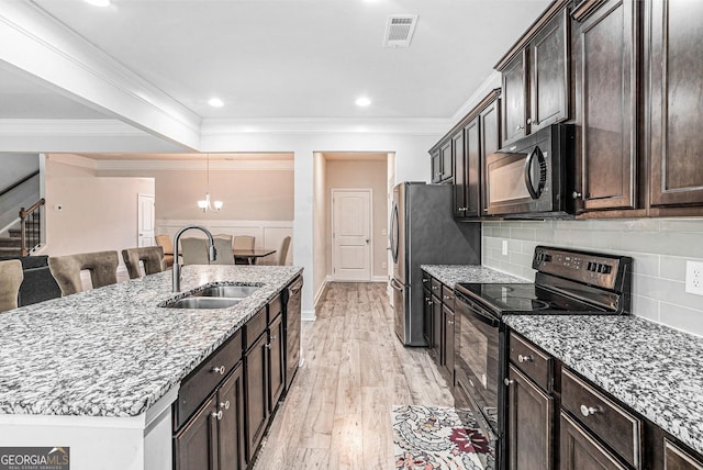 154 Laurel Cove Dr, Hoschton, GA 30548 - kitchen with black appliances, light wood finished floors, light stone countertops, crown molding, and an island with sink