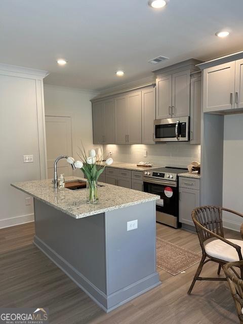 322 Heron St, Ball Ground, GA 30107 - kitchen featuring appliances with stainless steel finishes, gray cabinets, wood finished floors, crown molding, and recessed lighting